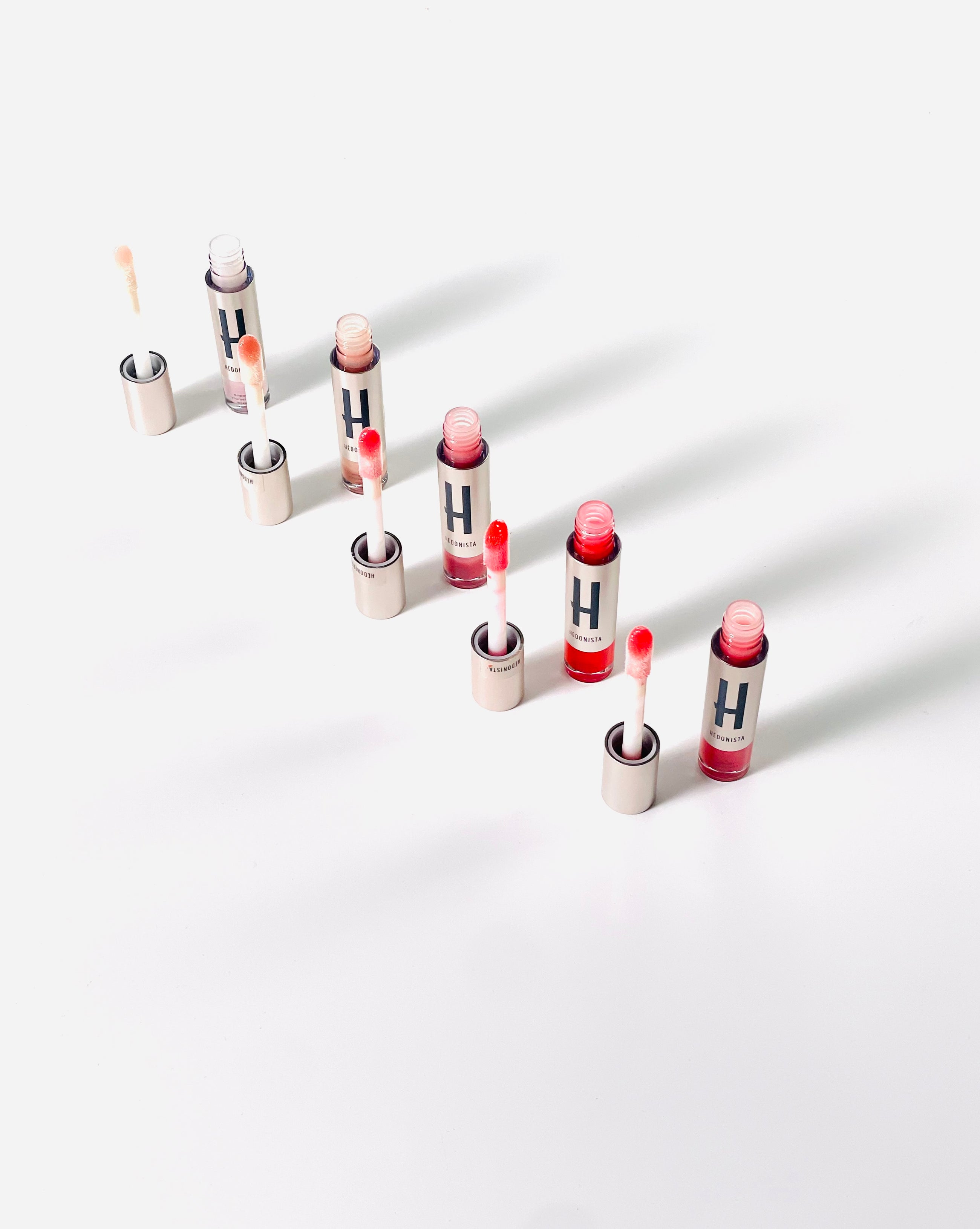 Błyszczyki do ust Hedonista w eleganckich opakowaniach z aplikatorem – prezentacja różnych odcieni
