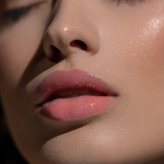 Błyszczyk do ust Hedonista Like A Virgin Lipgloss – naturalny różowy odcień z intensywnym połyskiem na ustach modelki