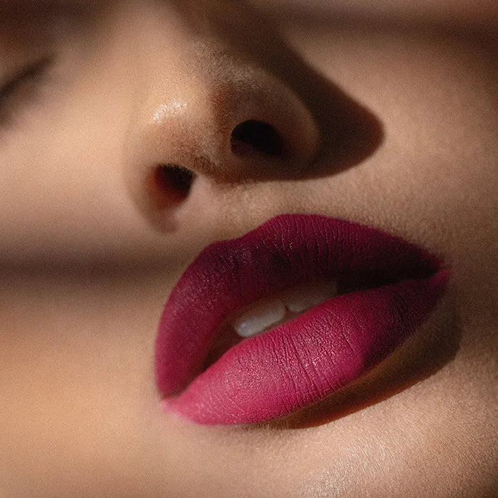 Matowa pomadka Hedonista About Her Lipstick – głęboki malinowo-śliwkowy odcień na ustach modelki