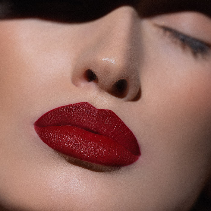 Matowa pomadka Hedonista Daltonista Lipstick – głęboki, intensywny czerwony odcień na ustach modelki