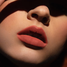 Matowa pomadka Hedonista Dama Lipstick – elegancki, pudrowo-różowy odcień na ustach modelki