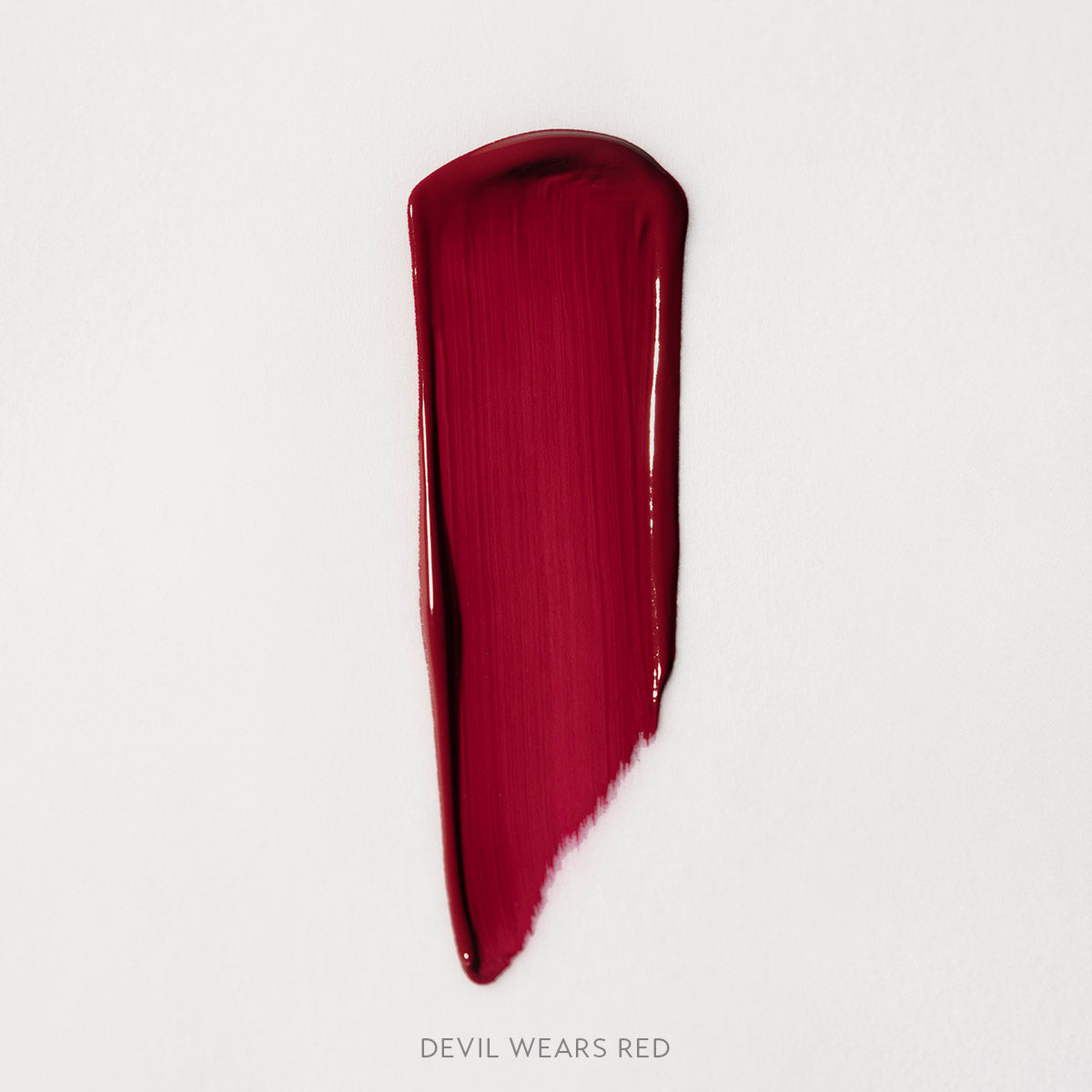 Matowa pomadka Hedonista Devil Wears Red Lipstick – intensywny, chłodny czerwony odcień, swatch produktu