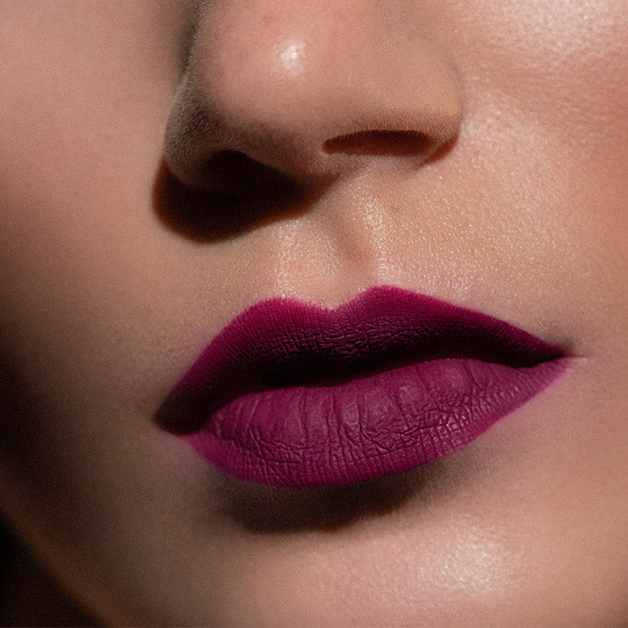 Matowa pomadka Hedonista Lady Kung Fu Lipstick – intensywny purpurowo-fuksjowy odcień na ustach modelki