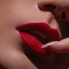 Matowa pomadka Hedonista Red-a-porter Lipstick – klasyczny, czysty czerwony odcień na ustach modelki