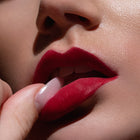 Matowa pomadka Hedonista Stop Lipstick – intensywny, klasyczny czerwony odcień na ustach modelki