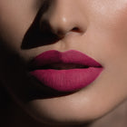 Matowa pomadka Hedonista Ugly Betty Lipstick – intensywny malinowo-różowy odcień na ustach modelki