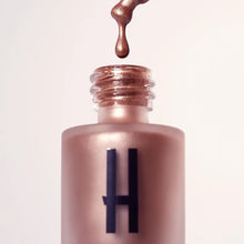 Płynny rozświetlacz Hedonista Miss Alchemist – metaliczna formuła i butelka z aplikatorem