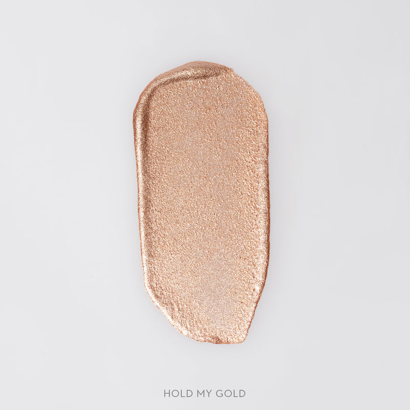 Rozmaz kremowego rozświetlacza Hold My Gold w odcieniu złotego szampana