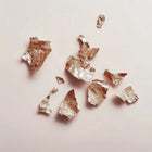 Złote, mineralne fragmenty o metalicznym połysku – inspiracja blaskiem rozświetlacza Hedonista Miss Alchemist