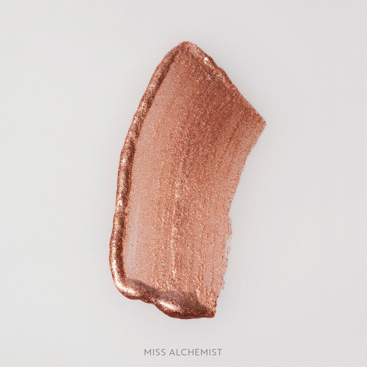 Rozmaz kremowego rozświetlacza Miss Alchemist w odcieniu miedziano-szampańskim