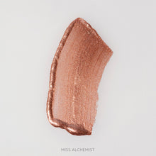 Rozmaz kremowego rozświetlacza Miss Alchemist w odcieniu miedziano-szampańskim