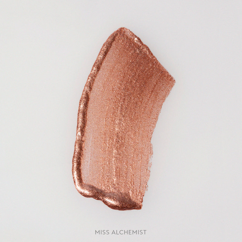 Rozmaz kremowego rozświetlacza Miss Alchemist w odcieniu miedziano-szampańskim